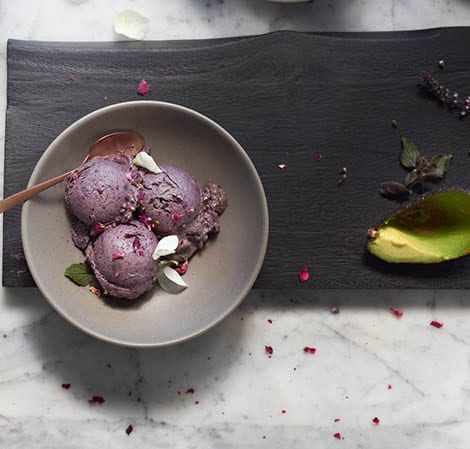 Blueberry Avocado Nice Cream blueberry avocado nice cream in a gray bowl with an avocado peel off to the side
