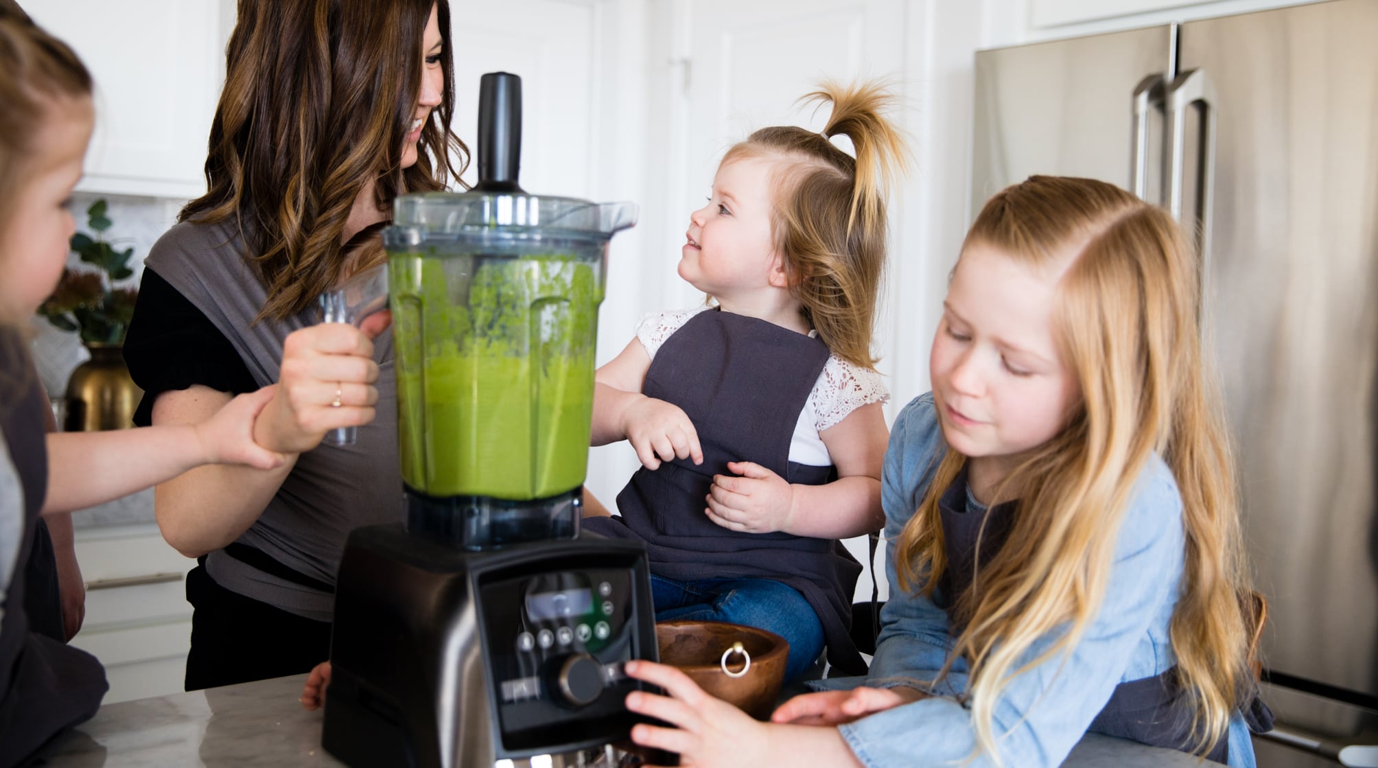 Happy family having fun using a Vitamix blender