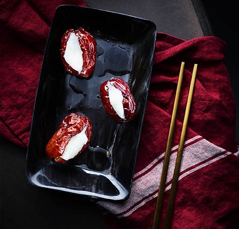 glutinious filled red dates on a platter