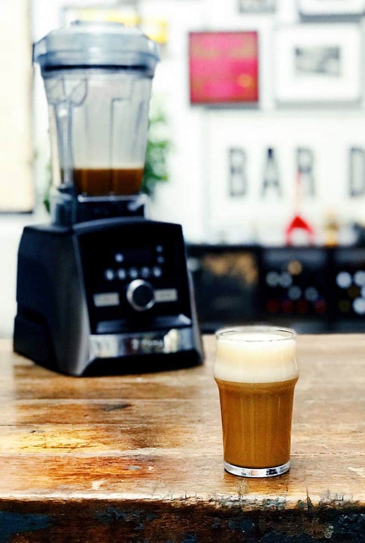 Coffee drink on wood table with Vitamix blender