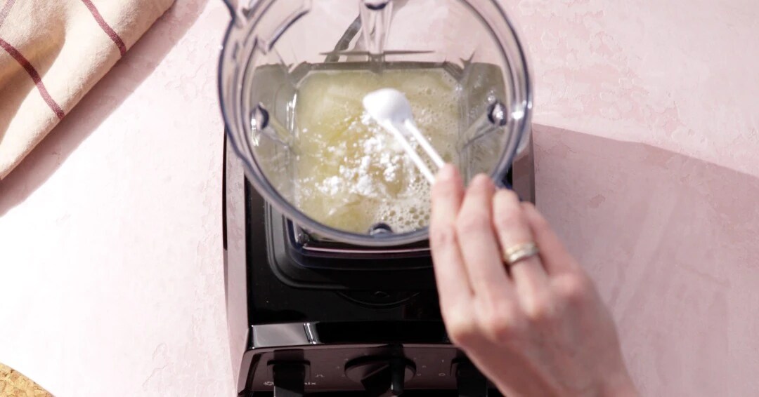 Spoon pouring white powder into the container